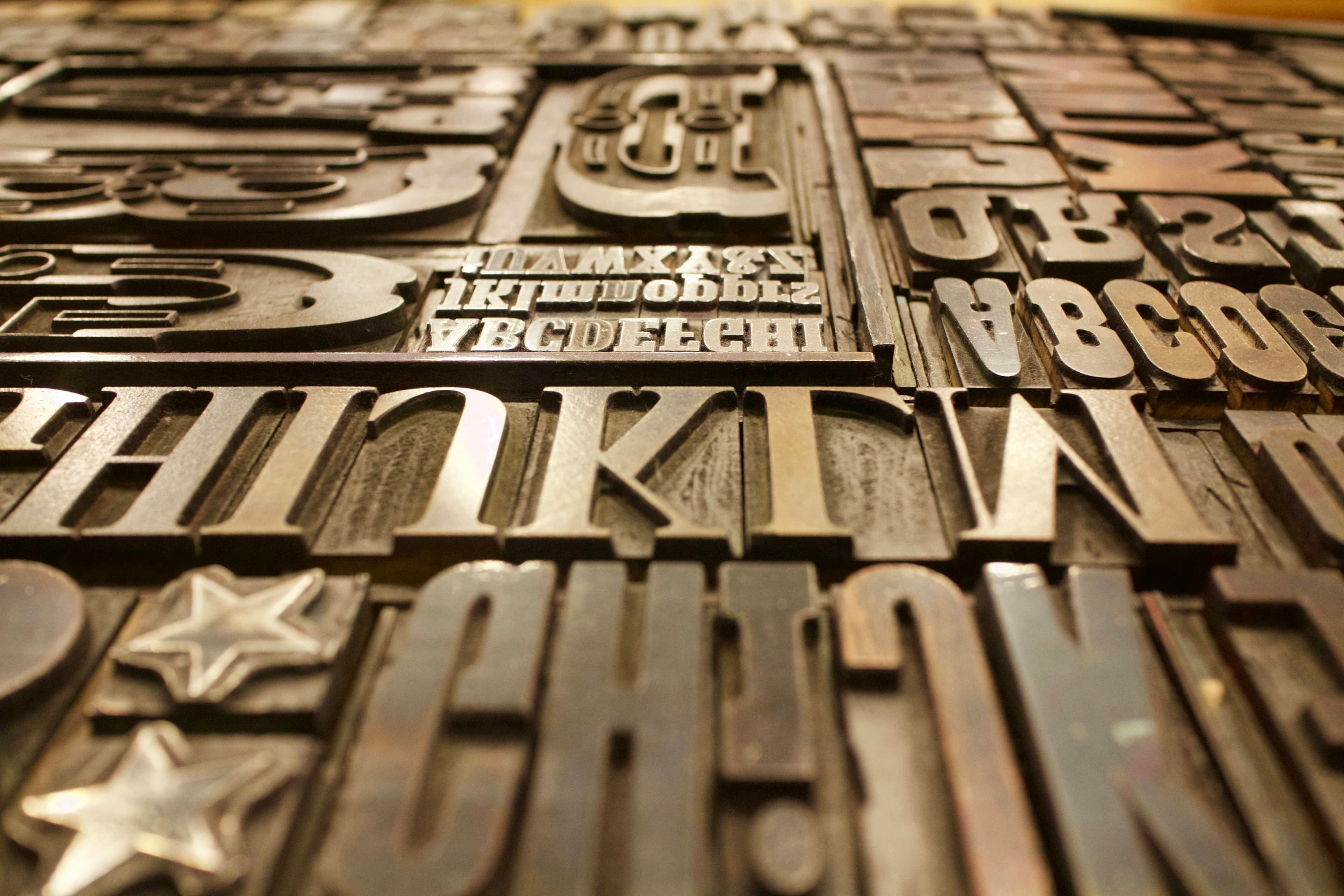Antique letterpress type blocks arranged in a case — evoking the craft of a printed, branded outreach letter.