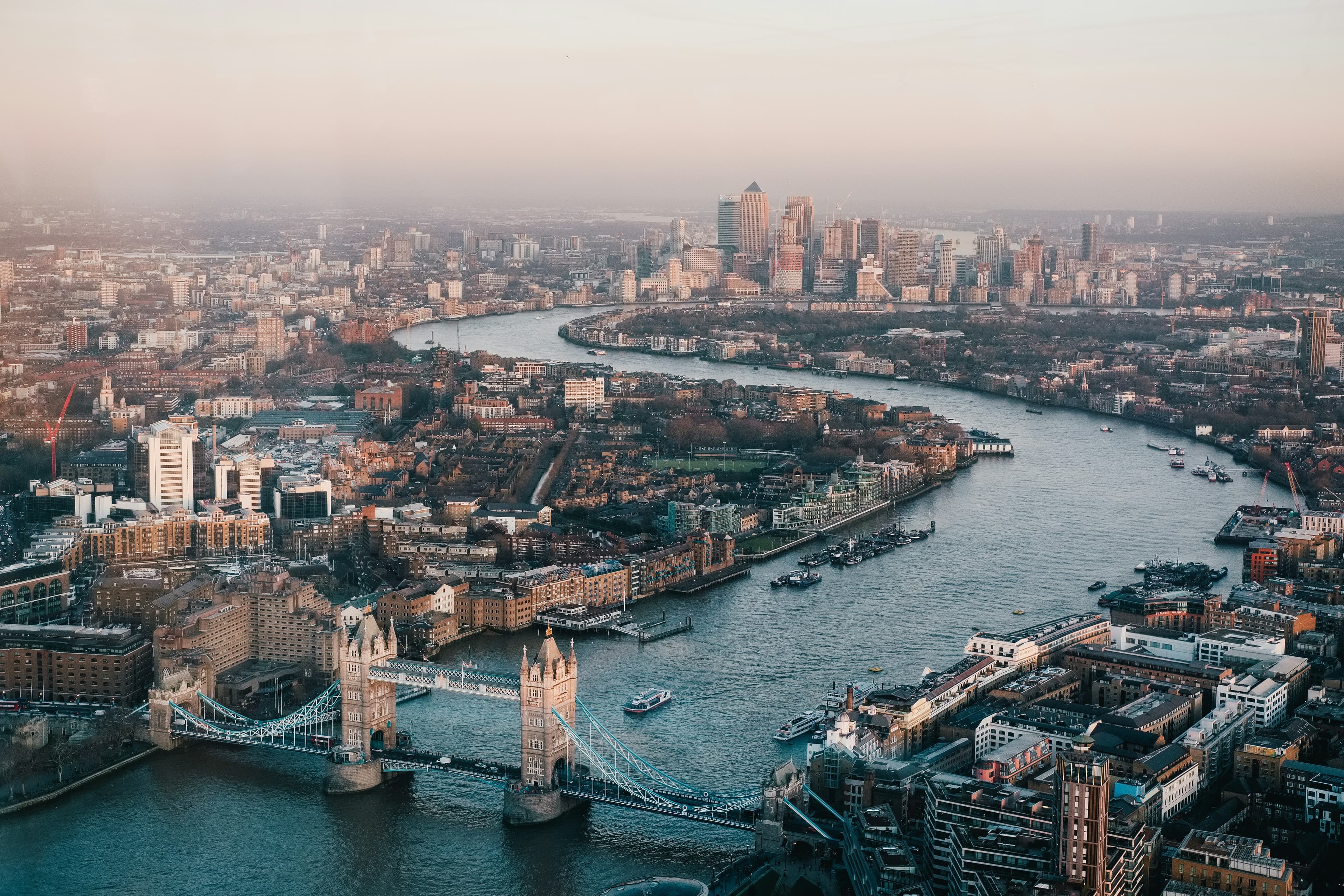 Aerial view of Tower Bridge, the River Thames and Canary Wharf at dawn — the kind of patch a BD team draws over in Plott.